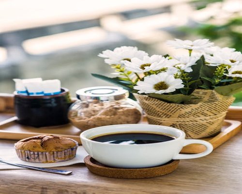 Fresh morning coffee cup on a table beside a bright window